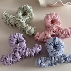 Detail of mercerized pleated fabric hair claws in pastel green pink purple and blue colors