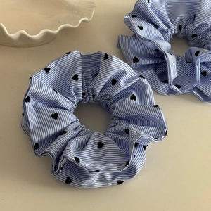 Lot de chouchous à rayures bleues et blanches avec motifs cœurs noirs sur fond épuré