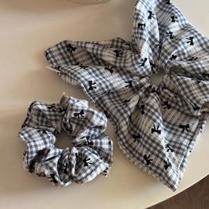Détail de chouchous à carreaux bleus et blancs avec motifs de nœuds noirs et étiquettes