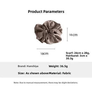 Detailed view showing a 18cm diameter brown polka dot satin scrunchie hair accessory