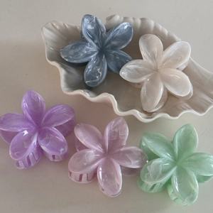 Detailed arrangement of five marble-textured flower hair claws in assorted pastel colors
