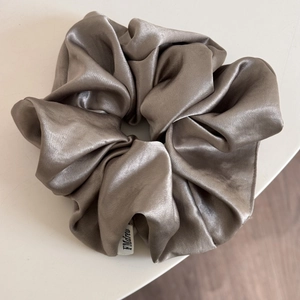 Close-up of elegant champagne satin oversized scrunchie with smooth silk texture