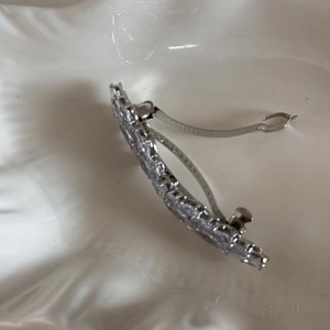Macro shot of silver bow hair clip showing side curve and secure metal spring clasp