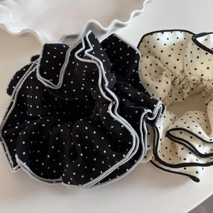 Close-up of black and white polka dot scrunchies with elegant four-layer ruffled edges