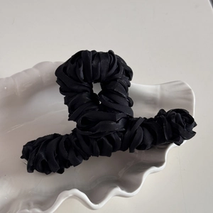 Macro detail of large black silk satin pleated ribbon wrapped hair claw shark clip