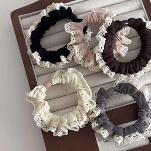 Five-pack set of soft lace trim scrunchies in neutral colors on a display tray