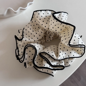 Detailed macro view of black and white polka dot large scrunchie with layered wavy edges