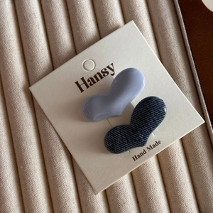 Close-up of heart-shaped hair clips in lavender gloss and blue denim texture finishes