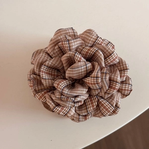 Macro view of British style plaid fabric rose flower hair claw clip with fine textures