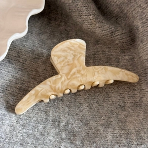 Detailed close-up of large marble texture hair claw clip with FRANCE Handmade engraving