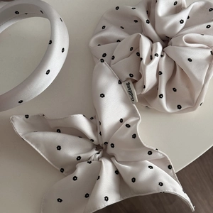 Detailed macro view of a pink satin floral scrunchie set with headband and ribbon bow