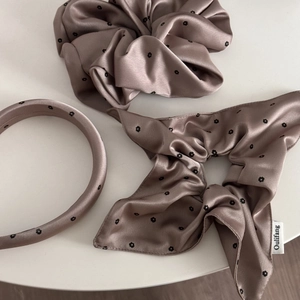 Detail of dusty pink satin scrunchies and headband set with delicate black floral print
