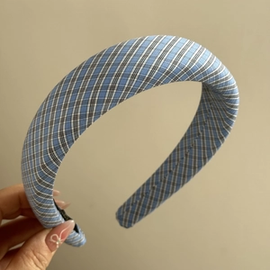 Gros plan sur le serre-tête rembourré à carreaux vichy bleus montrant la texture du tissu