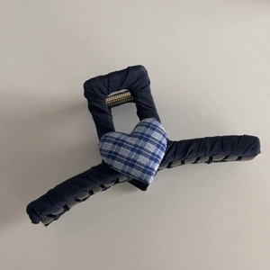 Detailed close-up of blue lace and plaid heart hair claw clip with vintage fabric texture