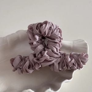 Close-up of Large mauve fabric-wrapped hair claw clip with pleated texture on shell tray