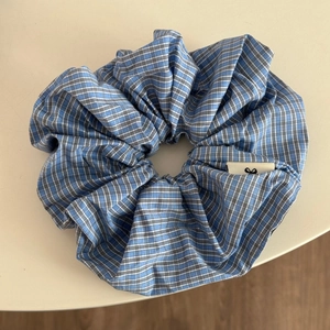 Gros plan d'un chouchou à carreaux bleu et blanc avec texture textile et étiquette nœud