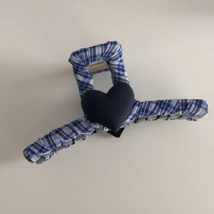 Detailed view of blue and white plaid lace hair claw clip with black 3D heart decor