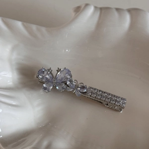 Detail of silver bow hair clip with purple pear-cut crystals and sparkly rhinestones