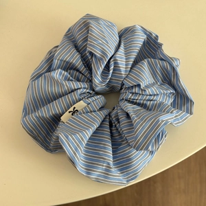 Gros plan d'un chouchou à rayures bleues et blanches avec de jolis plis et logo