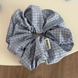 Détail d'un chouchou à carreaux bleus et blancs avec une petite étiquette de marque cousue