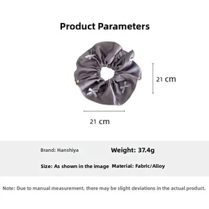 Detailed view of purple satin scrunchie with white bows showing 21cm diameter size