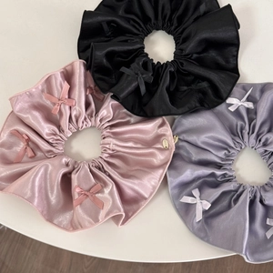 Elegant satin bow scrunchie set in black, pink, and lilac with a metallic logo detail