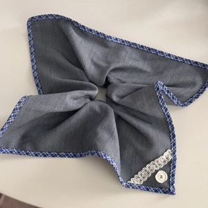 Detail of blue-gray lace hair scrunchie with checkered patterns and white button accents