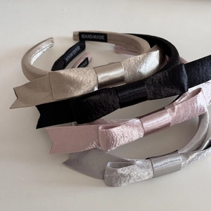 Détail de quatre serre-têtes en satin avec nœud et étiquette faite main en couleurs