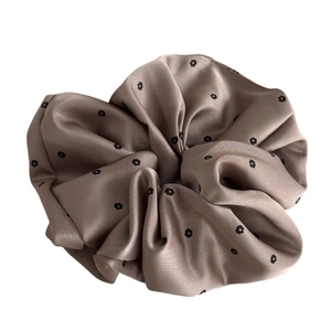 Elegant champagne satin scrunchie with minimalist floral print and pleated texture