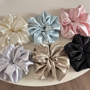 Detail of 6 large satin scrunchies in cream, blue, pink, purple, gold, and black