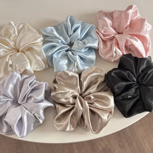 Detail view of 6-piece satin silk scrunchies set in pastel cream blue and pink tones