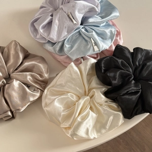 Set of large satin scrunchies in cream, pastel, and black shades with glossy silk texture