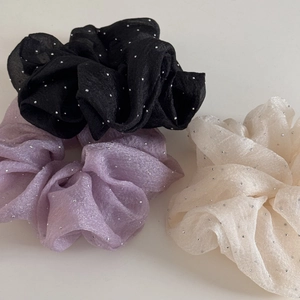 Détail de chouchous en tissu voilé avec strass argentés en noir, violet et beige