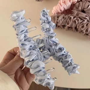 Detail of light blue pleated fabric texture on a large hair claw clip for thick hair