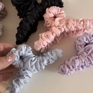 Close-up of silk pleated fabric claw clips in black, pink, blue and purple tones