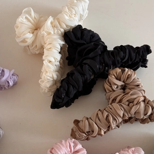 Close-up of pleated silk fabric hair claws in assorted pastel and neutral colors