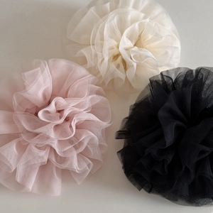 Detailansicht von gerüschten Netz-Scrunchies in Beige, Rosa und Schwarz mit Blumeneffekt