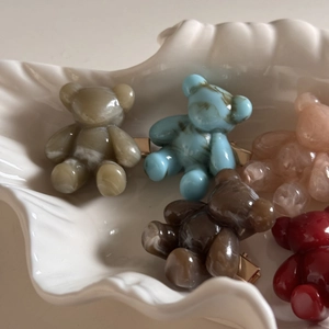 Close-up of cute cartoon bear resin hair clips in multiple colors with golden metal base