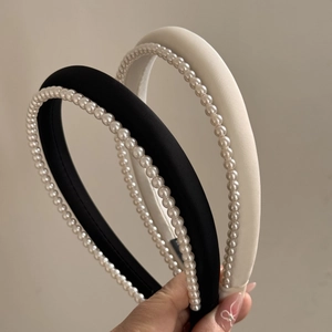 Detail of satin pearl headbands in black and white showcasing elegant beaded edges