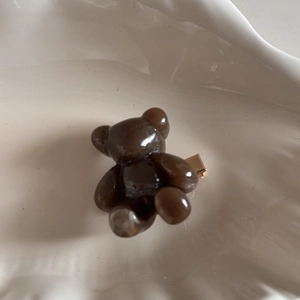 Detail of the brown resin cartoon bear hair clip with golden metal duckbill fastener