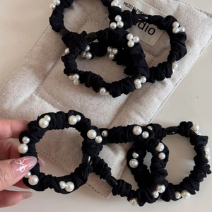 Elegant black scrunchie with white pearls for women hair styling in minimalist style