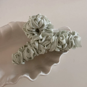 Detailed view of large mint green pleated satin fabric wrapped hair claw clip for women