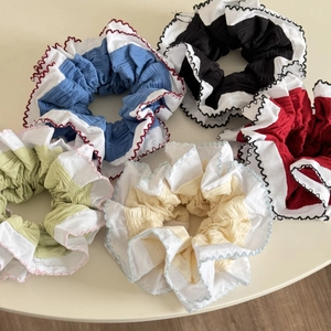 Détail de cinq chouchous plissés multicolores avec bords ondulés blancs festonnés