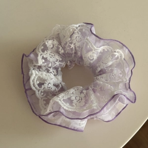 Detailed view of layered purple organza and white embroidered lace hair scrunchie texture