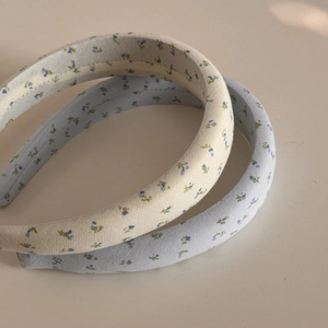 Detailed close-up of floral sponge headbands in light blue and cream fabric