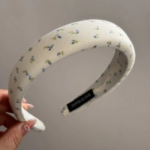 Detailed view of handmade floral sponge headband with delicate blue flowers pattern