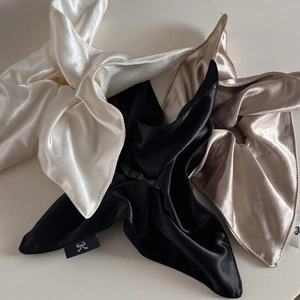 Close-up of premium square satin scrunchies with elegant bow details and silky texture