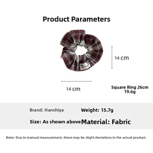 Detail of plaid scrunchie showing 14cm diameter size measurement and handmade label