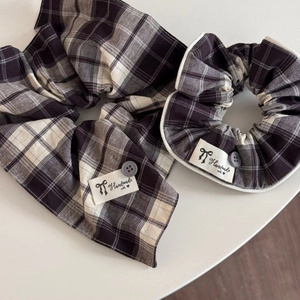 Detail of plaid scrunchies with decorative buttons and handmade fabric labels