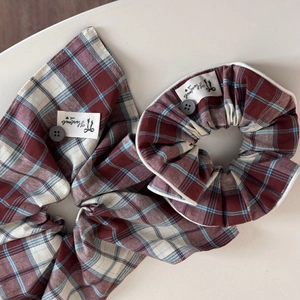 Detail view of plaid scrunchies with decorative buttons and handmade labels
